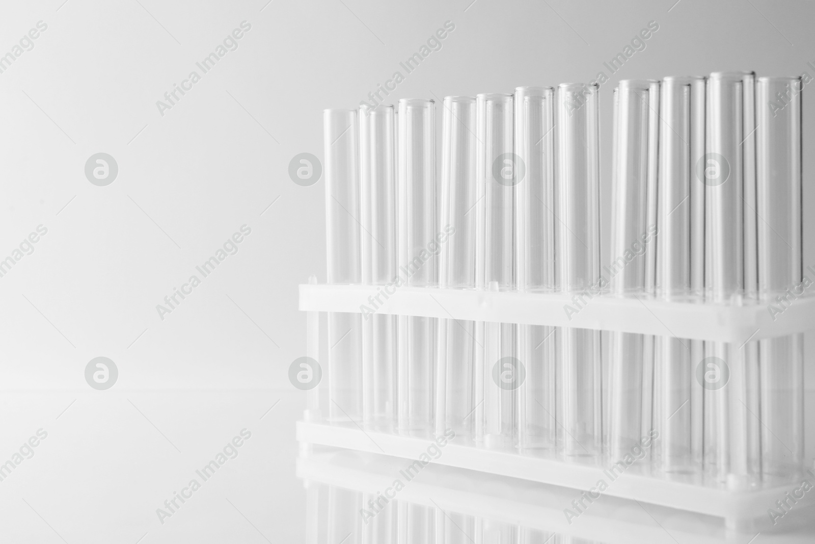 Photo of Empty test tubes on light background, space for text. Laboratory glassware