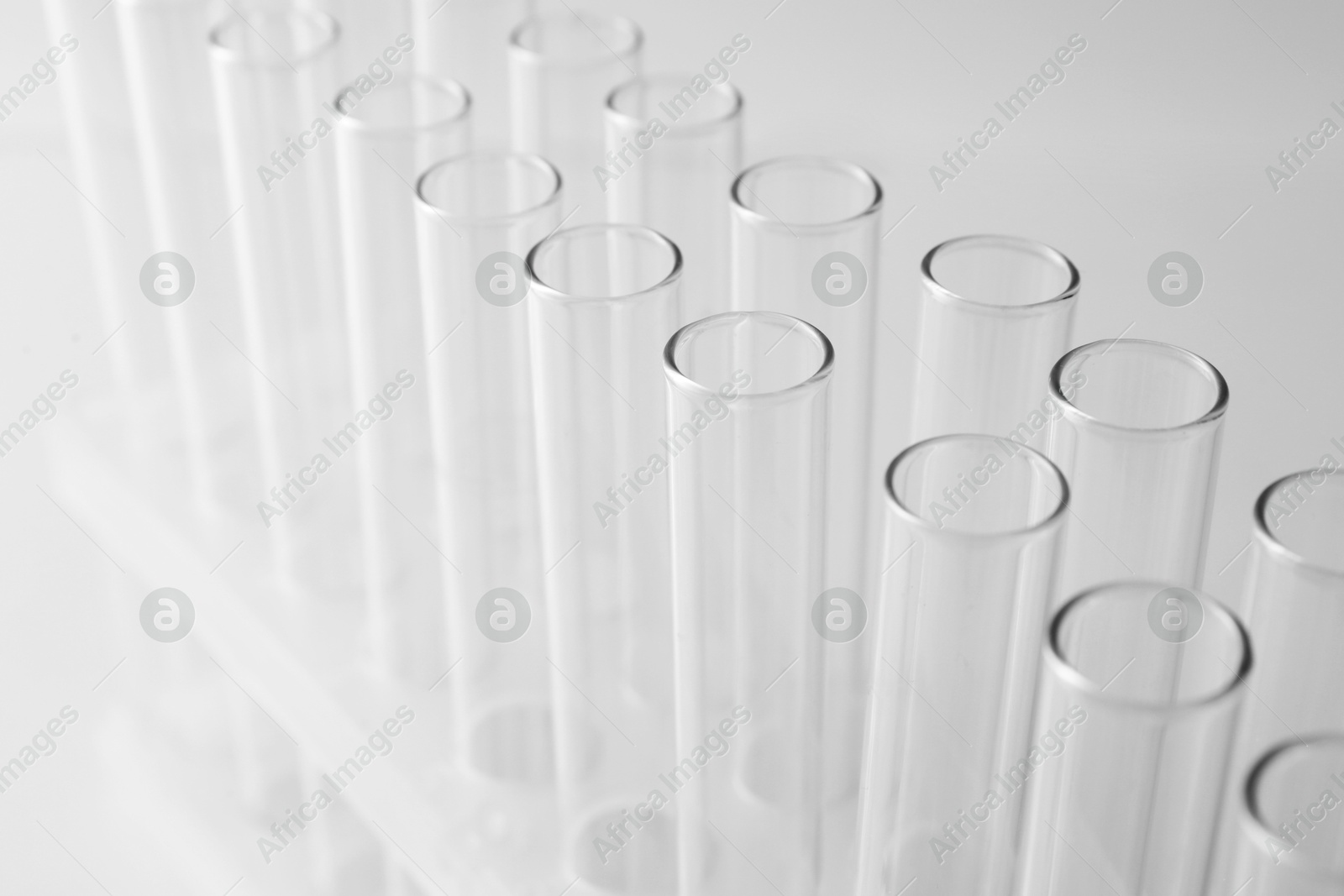 Photo of Empty test tubes on light background, closeup. Laboratory glassware