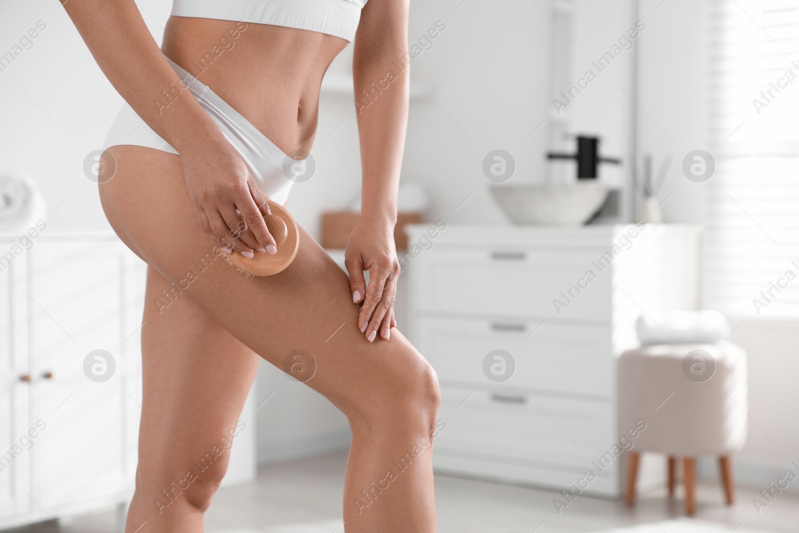 Photo of Woman doing anti cellulite massage with brush indoors, closeup. Space for text