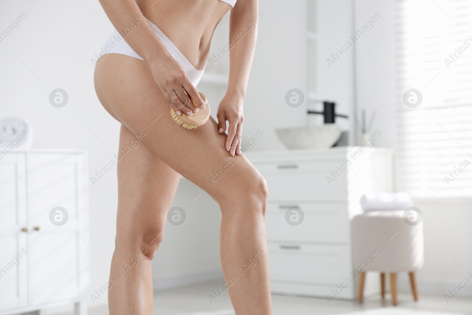 Photo of Woman doing anti cellulite massage with brush indoors, closeup. Space for text