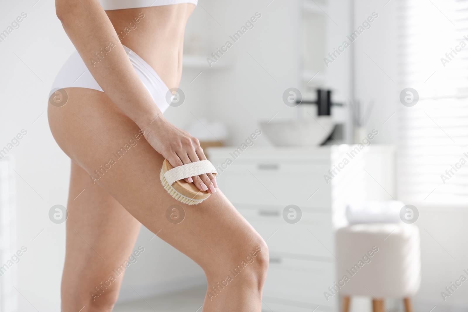 Photo of Woman doing anti cellulite massage with brush indoors, closeup. Space for text