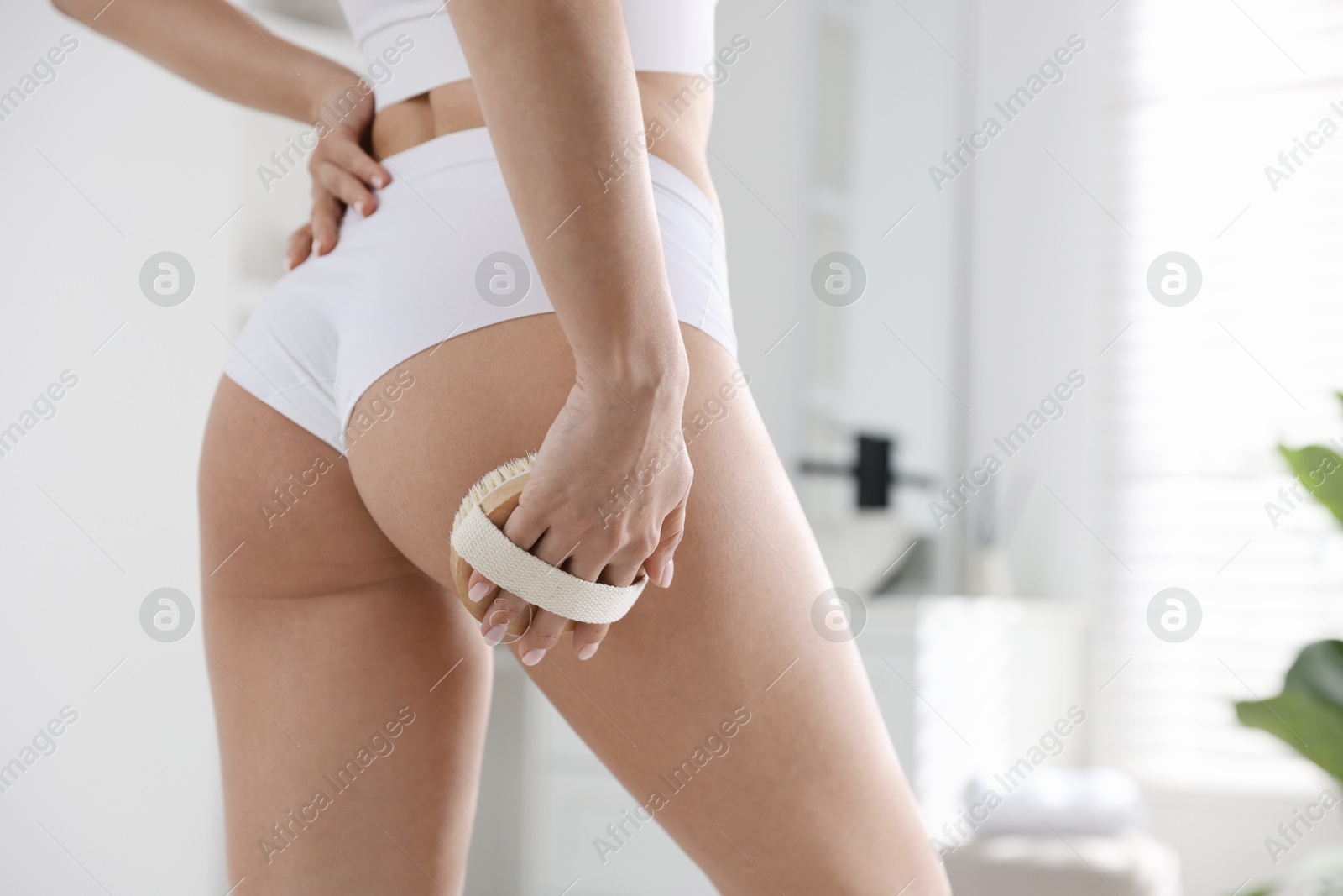 Photo of Woman doing anti cellulite massage with brush indoors, closeup. Space for text