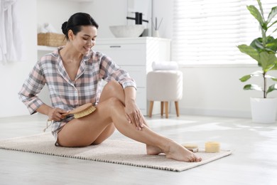 Woman doing anti cellulite massage with brush indoors. Space for text