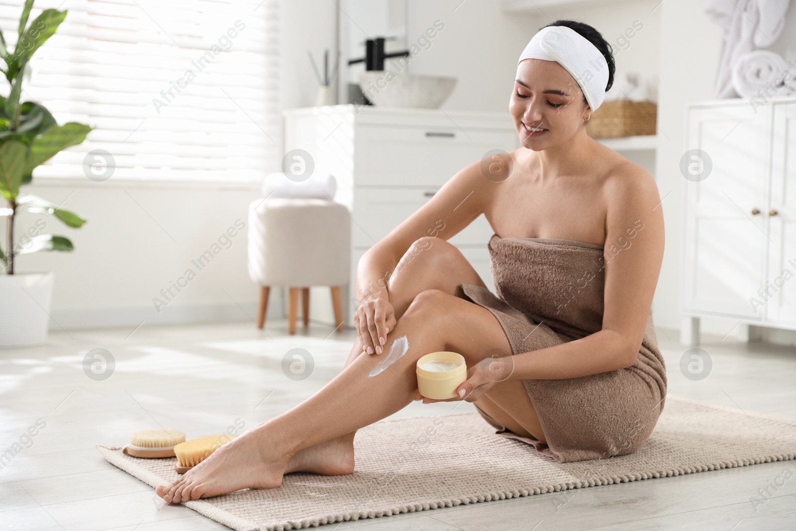 Photo of Woman applying anti cellulite cream indoors. Space for text