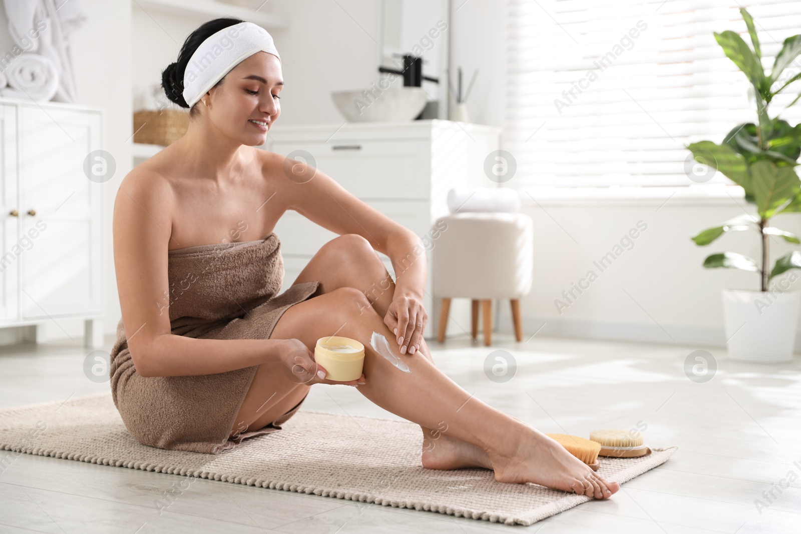 Photo of Woman applying anti cellulite cream indoors. Space for text