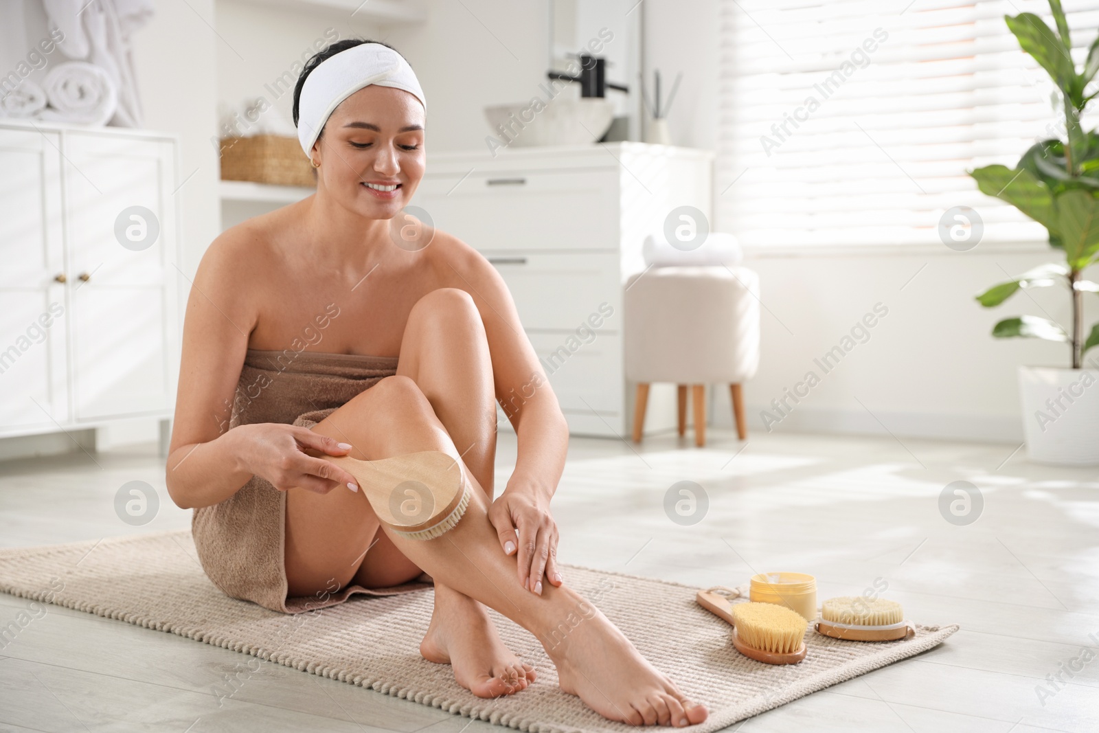 Photo of Woman doing anti cellulite massage with brush indoors. Space for text