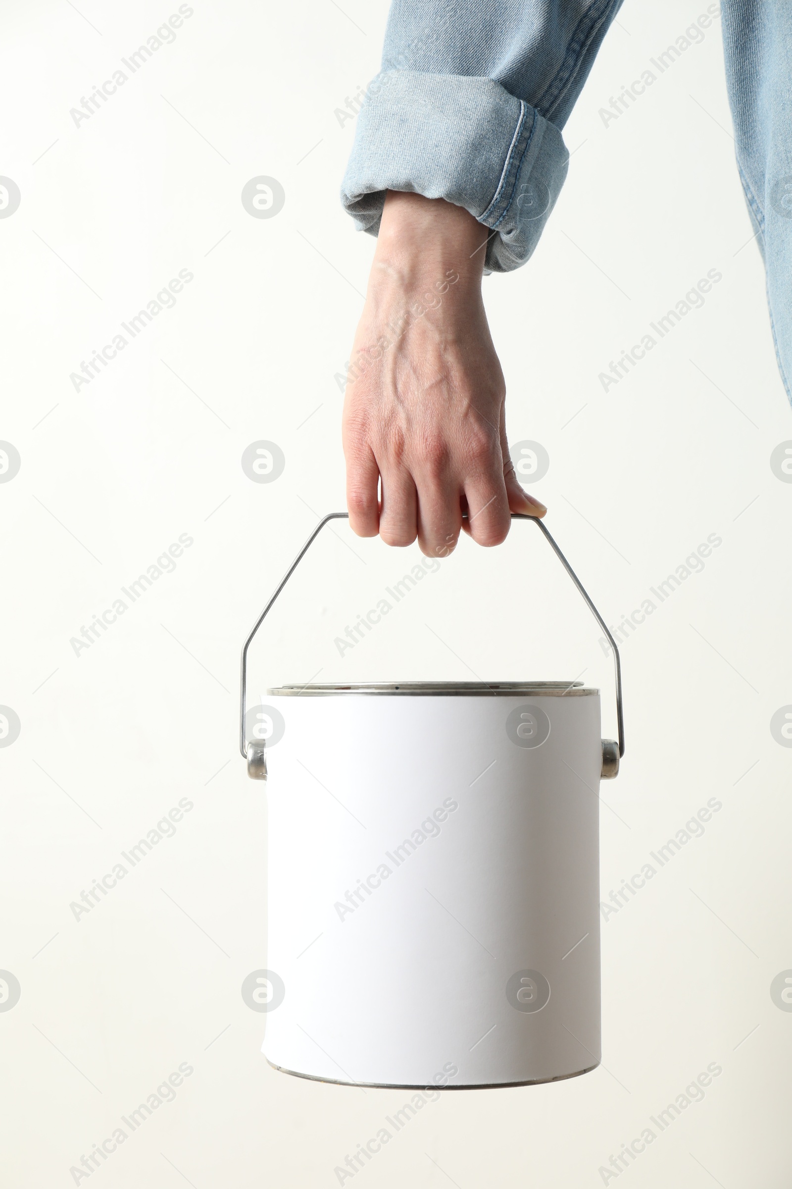 Photo of Woman holding bucket of paint on white background, closeup