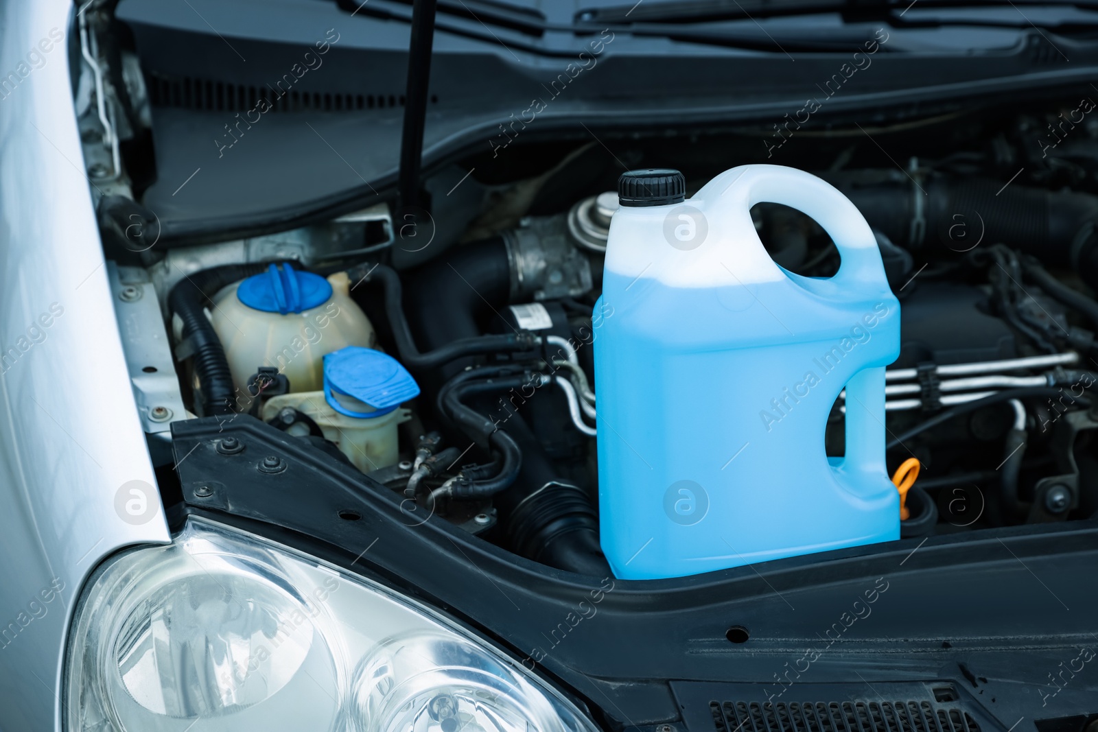 Antifreeze in plastic canister under hood of car Photo of Antifreeze in plastic canister under hood of car