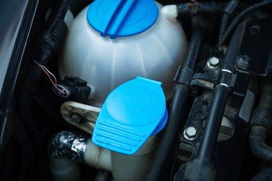 Photo of Windshield washer and coolant reservoirs in engine compartment, closeup