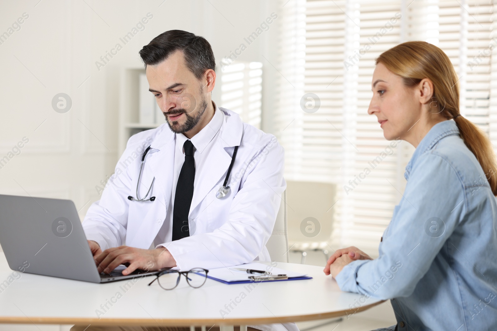 Photo of Woman having consultation with cardiologist at desk in clinic