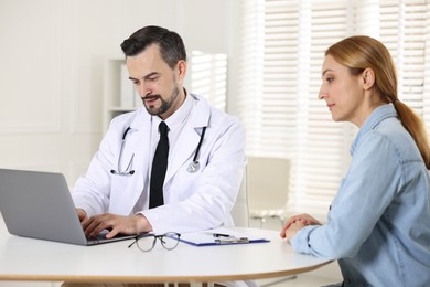 Photo of Woman having consultation with cardiologist at desk in clinic