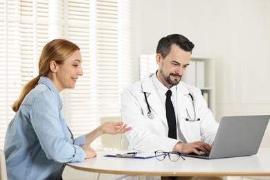 Photo of Woman having consultation with cardiologist at desk in clinic