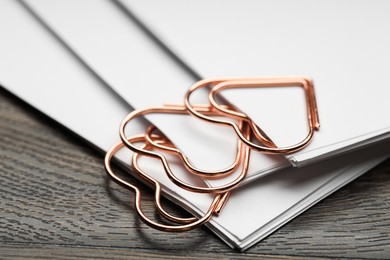 Metal paper clips and notes on wooden table, closeup