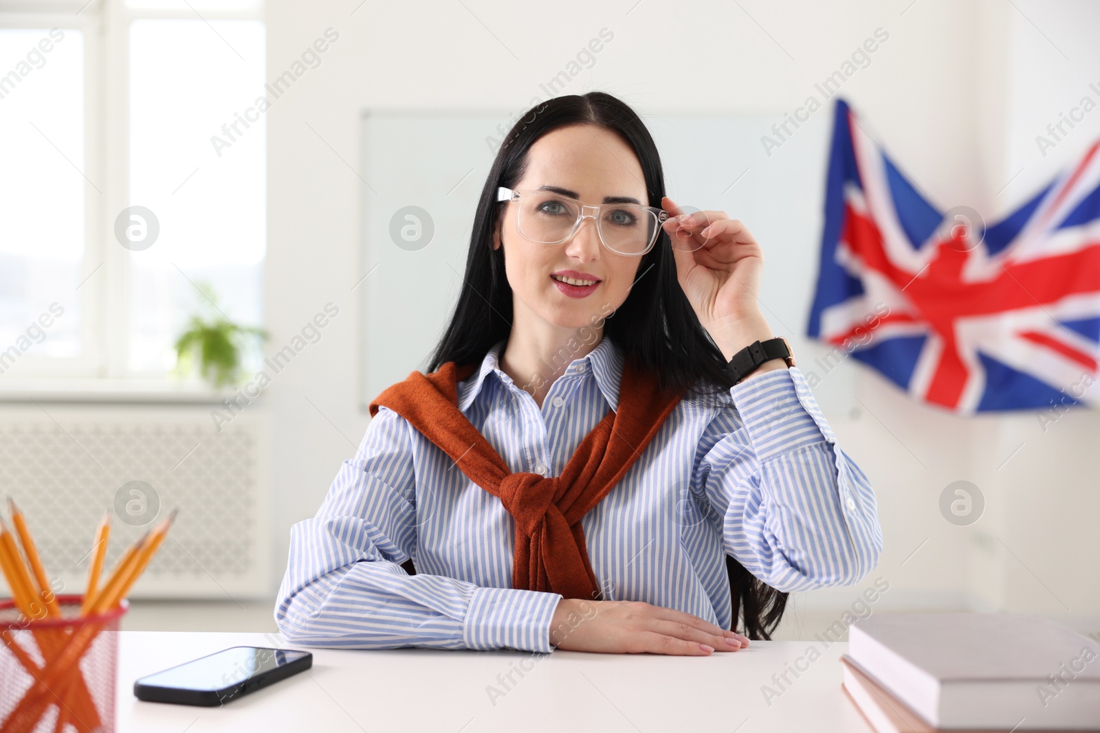 Photo of English teacher working at desk in classroom