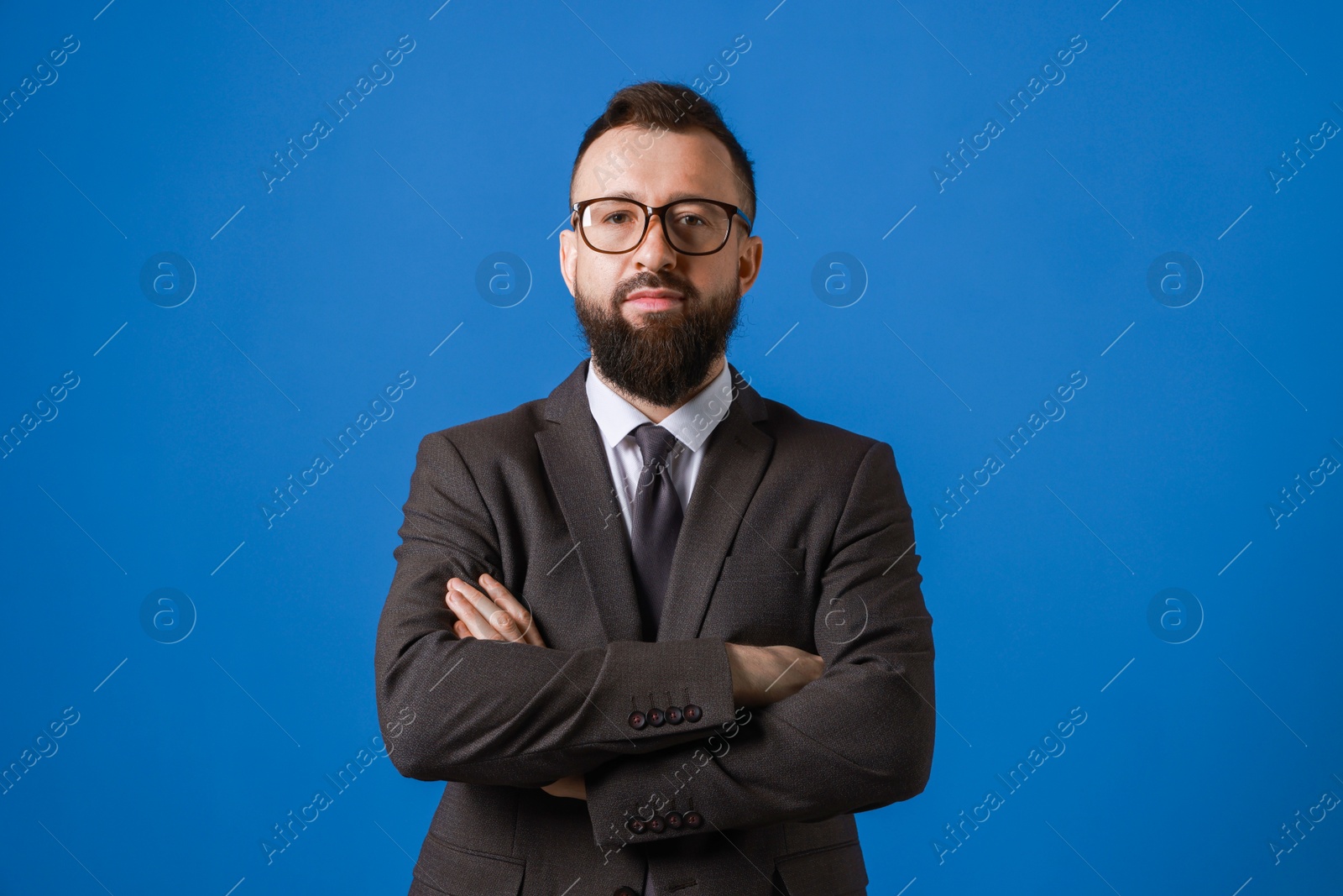 Photo of Handsome bearded man in suit on blue background