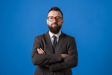 Handsome bearded man in suit on blue background