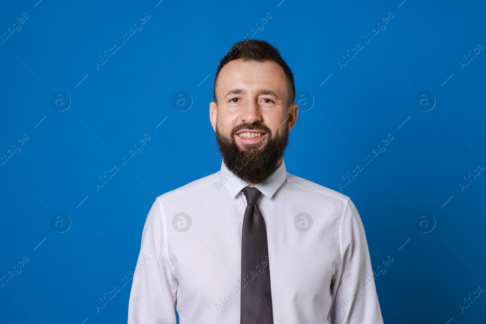 Photo of Handsome bearded man in formal outfit on blue background