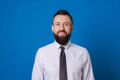 Photo of Handsome bearded man in formal outfit on blue background