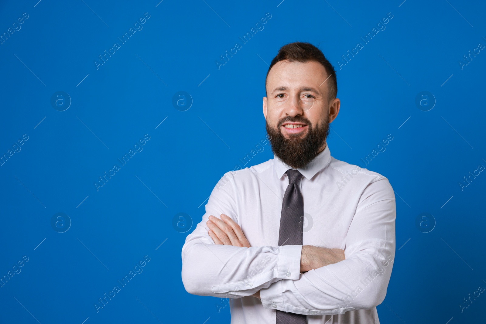 Photo of Handsome bearded man in formal outfit on blue background. Space for text