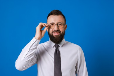 Photo of Handsome bearded man in formal outfit on blue background