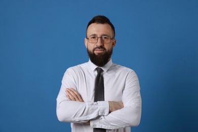 Handsome bearded man in formal outfit on blue background