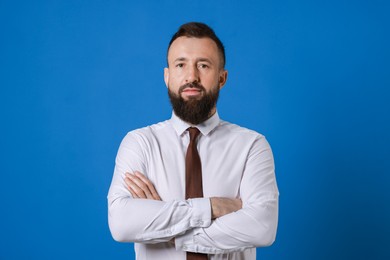 Handsome bearded man in formal outfit on blue background