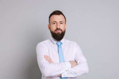 Handsome bearded man in formal outfit on grey background