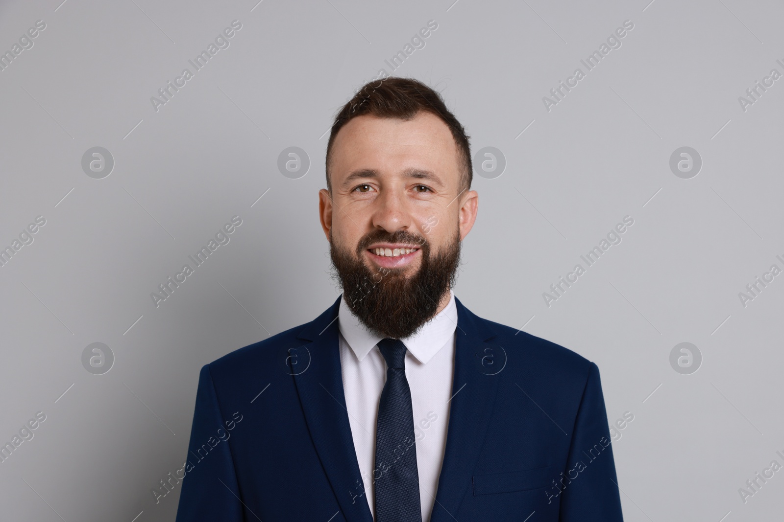 Photo of Handsome bearded man in suit on grey background