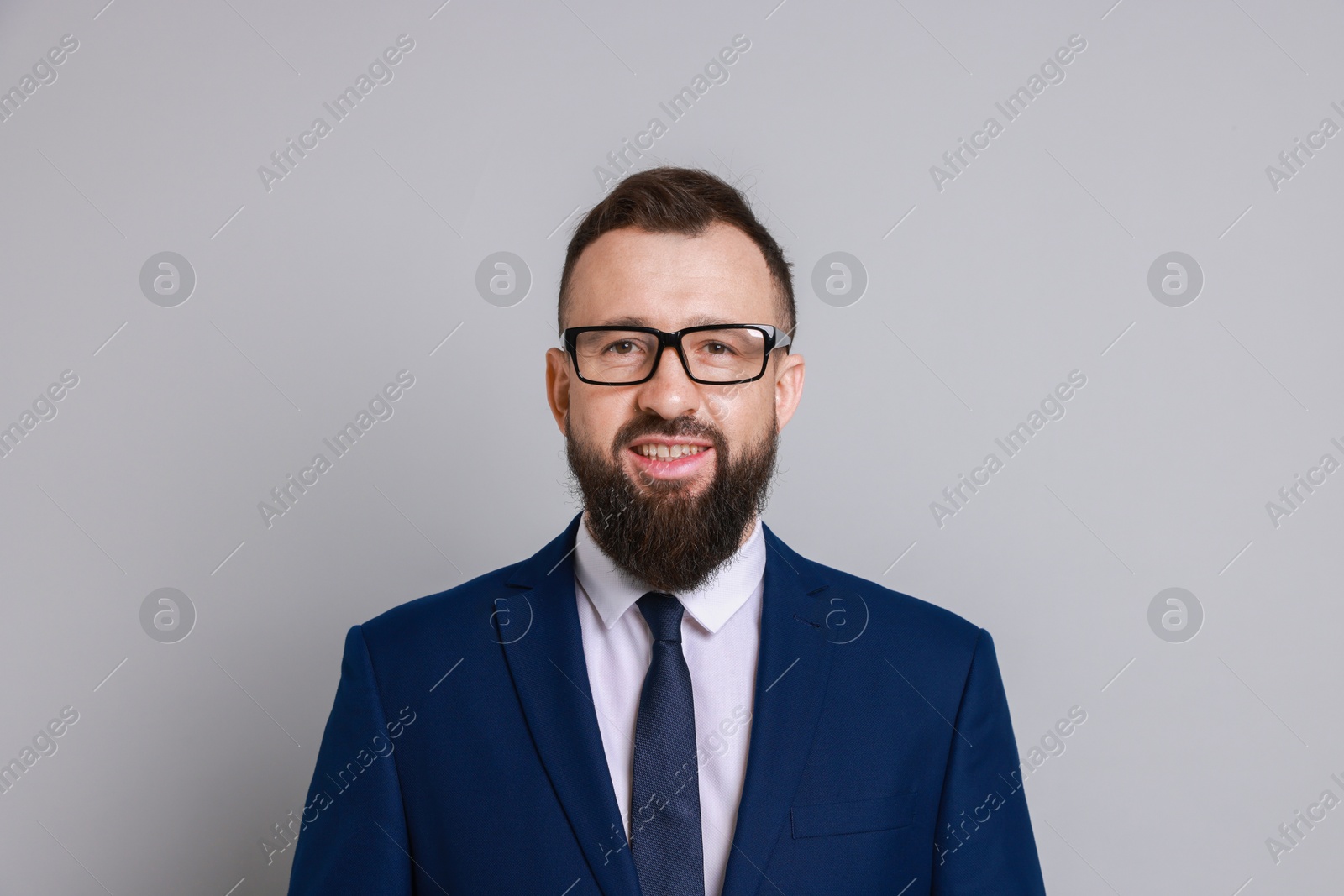 Photo of Handsome bearded man in suit on grey background