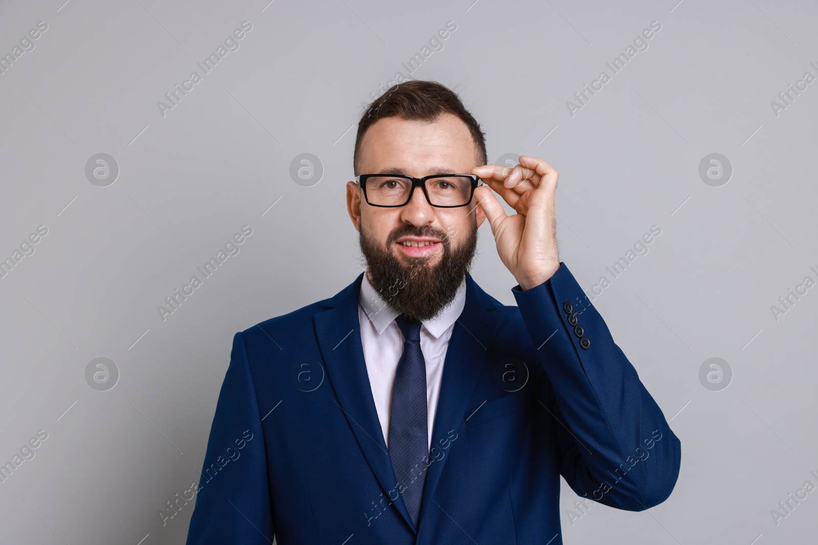 Photo of Handsome bearded man in suit on grey background