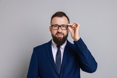 Handsome bearded man in suit on grey background