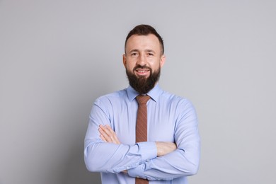 Handsome bearded man in formal outfit on grey background