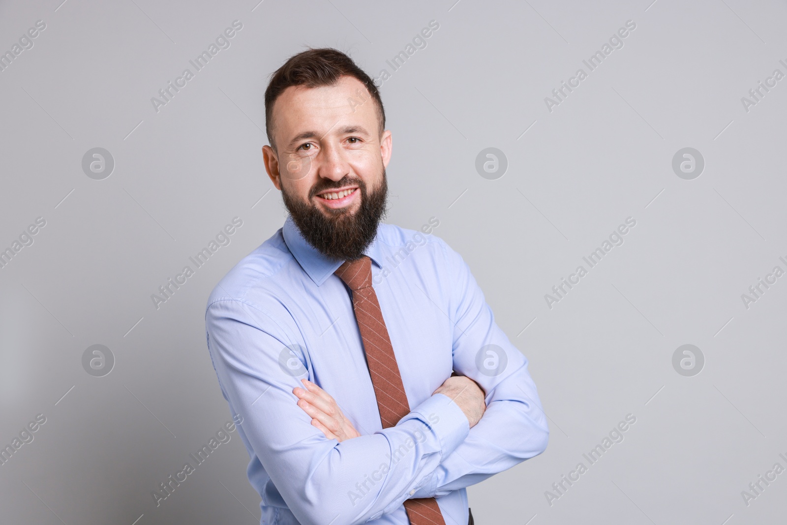 Photo of Handsome bearded man in formal outfit on grey background. Space for text