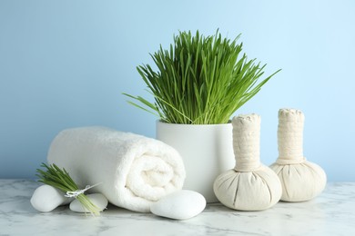 Photo of Spa composition with wheatgrass on white marble table