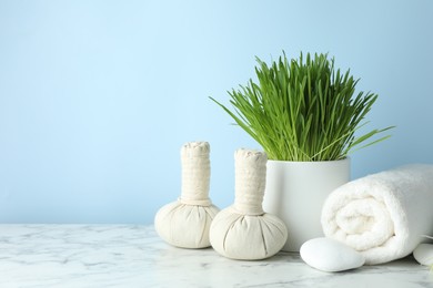 Photo of Spa composition with wheatgrass on white marble table. Space for text