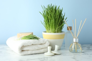 Photo of Spa composition with wheatgrass on white marble table