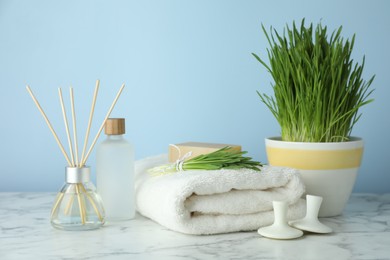 Photo of Spa composition with wheatgrass on white marble table