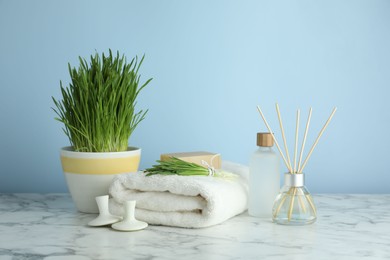 Photo of Spa composition with wheatgrass on white marble table. Space for text