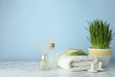 Photo of Spa composition with wheatgrass on white marble table. Space for text