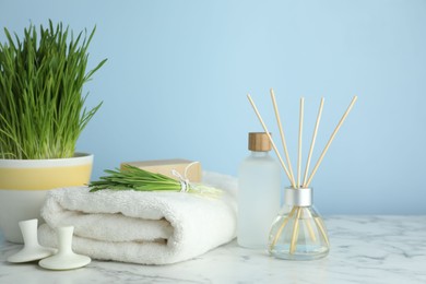 Photo of Spa composition with wheatgrass on white marble table. Space for text