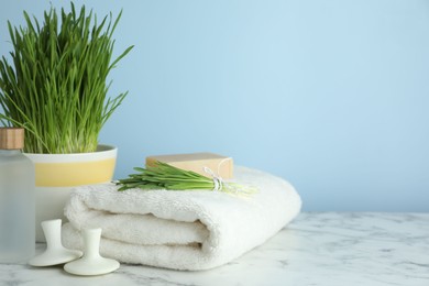 Photo of Spa composition with wheatgrass on white marble table. Space for text