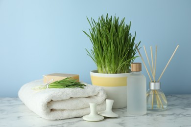 Photo of Spa composition with wheatgrass on white marble table. Space for text