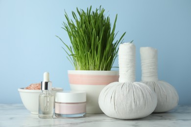 Photo of Spa composition with wheatgrass on white marble table