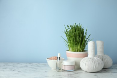 Photo of Spa composition with wheatgrass on white marble table. Space for text