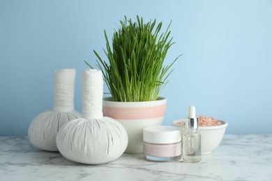 Photo of Spa composition with wheatgrass on white marble table