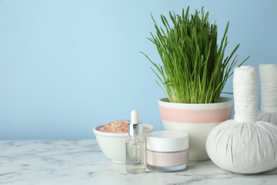 Photo of Spa composition with wheatgrass on white marble table. Space for text