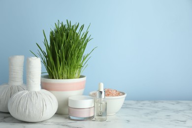 Spa composition with wheatgrass on white marble table. Space for text