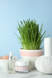 Photo of Spa composition with wheatgrass on white marble table