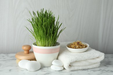 Photo of Spa composition with wheatgrass on white marble table