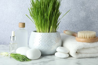 Photo of Spa composition with wheatgrass on white marble table